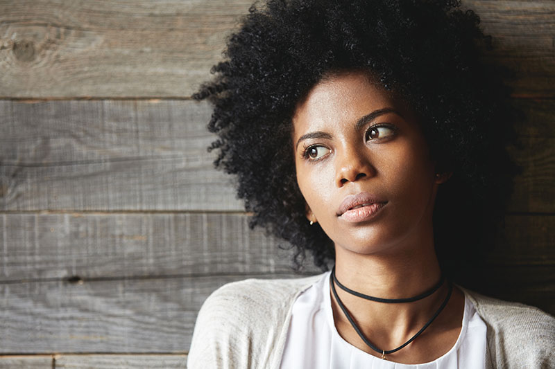 African-American woman looking off to side in contemplation.